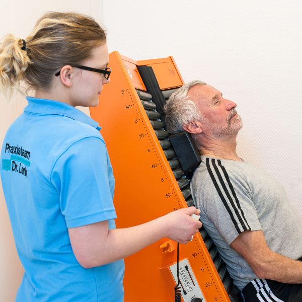 Patient bekommt Elektrotherapie auf einem Rollstreckvibramat in der Praxis für Orthopädie Dr. Gero Lenk Sonthofen